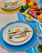Scalloped Summer paper placemats in blue, green, yellow and coral with contrasting outlines.