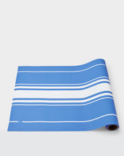 Summer paper table runner with white stripes on a blue background.