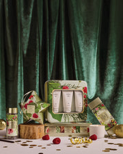 Christmas Candle Trio gift box with mini ceramic candles and other festive gifts against green velvet.