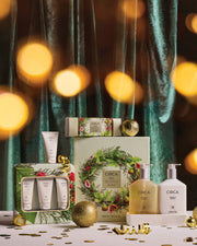 Mango & Papaya Hand Care Duo with other Christmas hand-care gifts, gold baubles and warm festive lights.