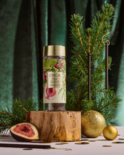 White Fig & Cedar Tree Scent Stems displayed on a small Christmas tree beside their botanical storage tube.