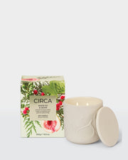 White Fig & Cedar 300g Soy Candle in an embossed ceramic vessel with lid, beside its front-facing botanical Christmas box.